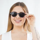 Lentes de sol con montura redonda color gris y detalles dorados en las patillas.