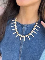 Collar corto con cadena dorada, cuentas de cerámica color crema con rayas marrones, pinchos de piedra reconstituida color crema y cristales checos.