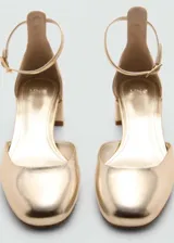 Zapato de tacón bloque color dorado, con punta redonda, efecto charol y cierre de tira con hebilla.