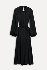 Vestido midi negro de cuello redondo y manga larga abullonada con puños. Tiene cintura elástica y detalle de espalda descubierta. El cierre es con botón en el cuello.