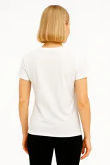 Remera negra de algodón con cuello en V y estampado de flores blancas.