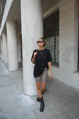 Conjunto de remera negra oversize y biker estampada con manchas color crema y negro.