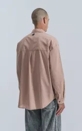 Camisa manga larga rosa con bolsillo con ojal y botón en delantero, de calce oversize confeccionada en textil plano fresco y liviano.