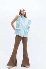 Chaleco celeste de lino con cuello mao, cierre frontal con botones y volados en hombros y bolsillos.