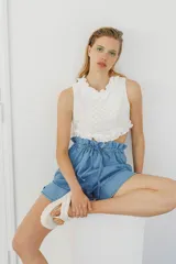 Top blanco de broderie con cuello halter y detalles de volados en el cuello y el ruedo.