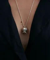 Collar plateado con dije en forma de amapola.