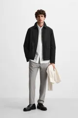 Pantalón slim fit negro confeccionado en tejido con elasticidad en ambas direcciones. Cuenta con bolsillos frontales y traseros de vivo con botón. Cierre frontal con cremallera y botón.