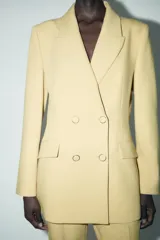 Blazer amarillo mostaza de cuello solapa y manga larga. Cierre frontal cruzado con botones forrados y bolsillos con solapa en delantero.