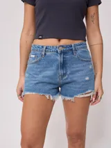Short de jean negro con roturas y terminaciones desflecadas.