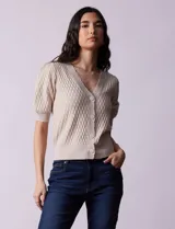 Cárdigan tejido color blanco, marca Tahari. Escote en V, manga corta abullonada con puño y abertura central con botones.