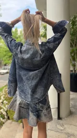 Minifalda de denim celeste con efecto lavado, corte acampanado y ruedo desflecado.