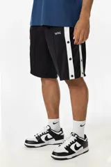 Bermuda deportiva negra de tela satinada con laterales con botones a presión y franja blanca en contraste. Logo Vernal bordado en blanco. Inspirada en la estética de los joggings adidas vintage.