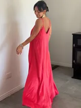 Vestido largo de satén color fucsia, con tirantes delgados y corte holgado.