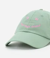 Gorra de béisbol de sarga color verde menta con visera curva. Presenta bordado frontal en hilo rosado con la frase "good days ahead" y pequeños detalles florales.
