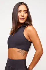 Top deportivo azul marino con cuello polo y cierre parcial con cremallera.