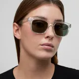Lentes de sol con montura cuadrada transparente y cristales polarizados en color verde oliva. Cuentan con protección UV400 y están fabricados con materiales bio-basados y patillas de propionato de celulosa.