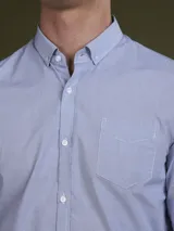 Camisa celeste con microestampado de rombos blancos, de corte clásico, manga larga y cuello abotonado.