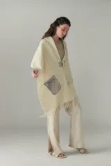 Chal de lana fina sin teñir, con calce en hombros, abrochadura con alamar de fieltro, bolsillos de cuero y terminación con flecos. Diseño exclusivo de Don Baez, hecho en Uruguay.