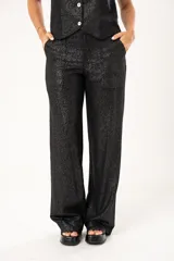 Pantalón negro de lino imperial con lurex, tiro medio, corte palazzo, bolsillos delanteros y traseros, y cierre frontal con cremallera y botón.