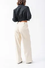 Camisa corta negra de algodón y elastano, con cuello clásico, mangas largas con puños elásticos, cierre frontal con botones y cintura elastizada.