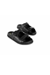 Sandalias planas negras de cuero con textura y múltiples correas ajustables con velcro.