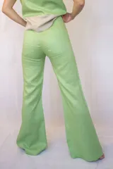 Pantalón de lino color verde claro, de corte recto y con aberturas en el ruedo.