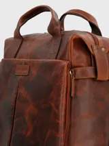 Mochila de cuero color marrón con doble asa de mano y correas acolchadas ajustables. Presenta un compartimento principal con cierre de cremallera, bolsillo acolchado interior para laptop, bolsillo interior con cierre, dos bolsillos frontales con cierre lateral, bolsillo trasero con cierre y forro interior de poliéster reciclado.