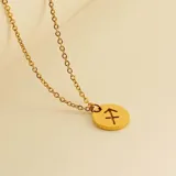 Collar dorado con dije redondo con el signo de Aries grabado.