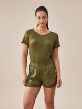 Short deportivo verde militar con calza interna, cintura elástica y logo estampado en la pierna.