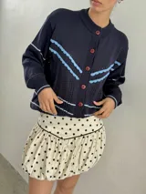 Saco calado azul marino con detalles en crochet celeste, de corte holgado y manga larga.