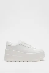 Zapatillas blancas con plataforma gruesa, cordones y puntera redonda.