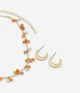 Conjunto de collar y aros dorados con cuentas de colores naranja y blanco.