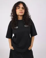 Remera negra de corte recto con estampado en la espalda con la palabra "Nude" en blanco, seguido de "PROJECT®CULT. BY ARTISTS FOR ARTISTS. EST. 2019".