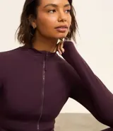 Campera deportiva negra confeccionada en poliamida y elastano, con cuello alto, cierre delantero por cremallera y bolsillos laterales.