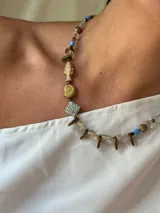 Collar corto con cuentas de cristal checo y cristal facetado en tonos azul, dorado y transparente. Cierre de acero quirúrgico con cadena para regular el largo.