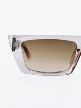 Lentes de sol rectangulares con marco transparente y lentes marrones degradadas.