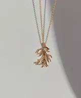 Collar plateado con dije en forma de coral. El dije tiene una textura rugosa y un diseño intrincado que imita la forma natural del coral. La cadena es de eslabones finos y delicados.