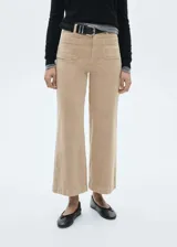 Pantalón culotte color beige de pana con tiro alto, corte ancho, largo cropped y bolsillos delanteros de parche. Incluye cinturón negro con hebilla plateada.