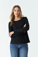 Remera negra de algodón, de corte recto, manga larga y cuello redondo.