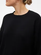 Sweater negro de punto con cuello redondo, mangas largas y hombros caídos.