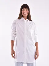 Camisa blanca oversize de manga larga con cuello clásico y bolsillo en el pecho.
