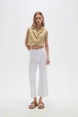 Pantalón jean blanco, recto y de calce alto con terminación desflecada.