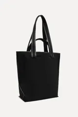 Bolso tipo tote confeccionado en algodón color negro, con doble asa y detalle de parche con el logo "50" y la leyenda "A Coruña".
