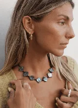 Collar corto con cuentas cuadradas de nácar negro iridiscente, separadores de cristal facetado y cierre de acero.