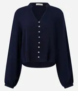 Camisa azul marino de viscosa con cuello mao, cierre frontal con botones y mangas largas con puños elásticos.