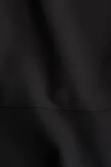 Top negro de manga corta con escote redondo y peplum acampanado en la parte inferior.