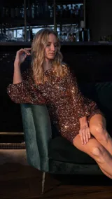 Vestido dorado con lentejuelas, de corte ajustado y manga larga, ideal para ocasiones especiales.