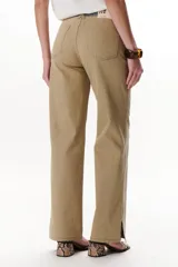 Pantalón jean de corte recto color beige con cinturón gris.