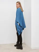 Ruana de tejido suave color morado oscuro, con cuello redondo y corte amplio tipo capa.