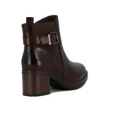 Bota de cuero color marrón oscuro, de caña baja y taco cuadrado. Presenta detalle de hebilla metálica en el lateral.